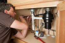 garbage disposal installation a Foster City plumber is installing a garbage disposal